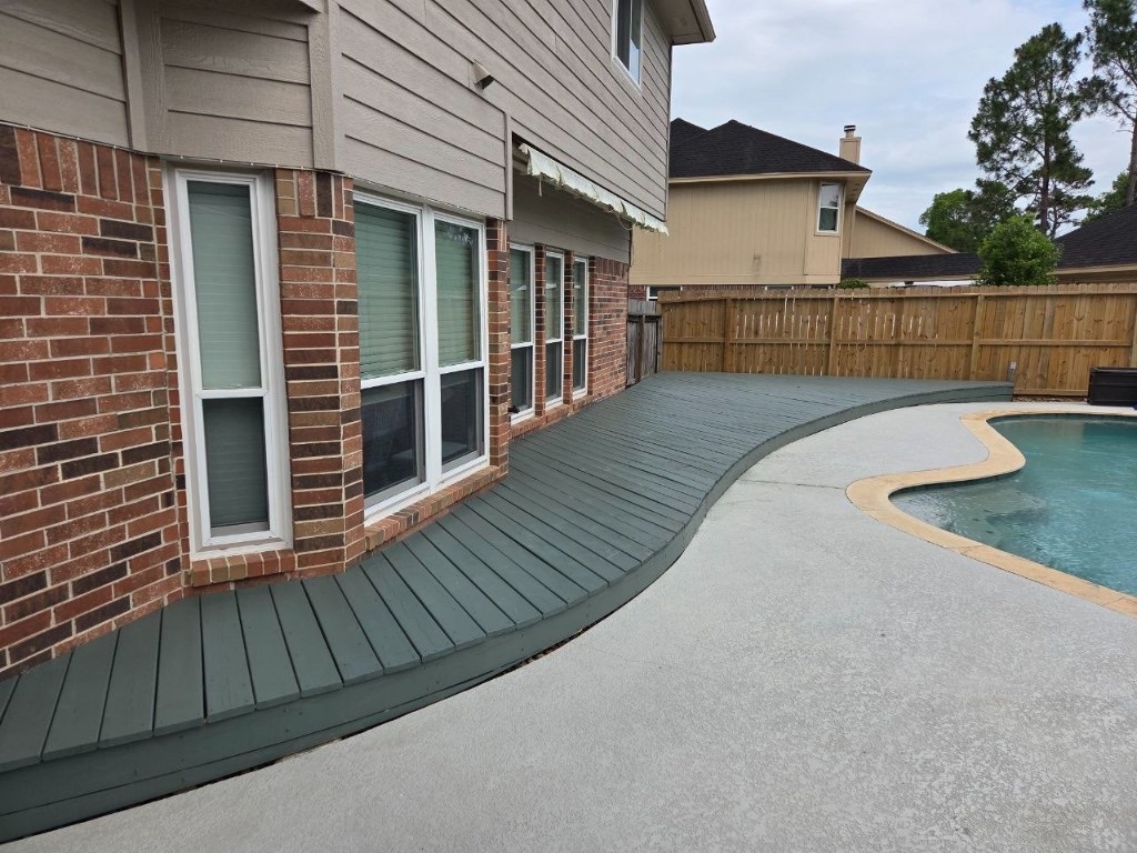 Finished curved deck stained slate-grey beside the pool